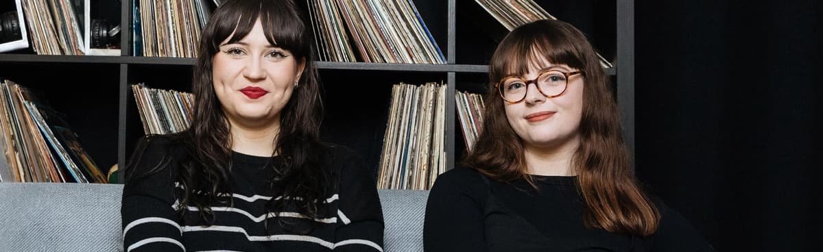 I ricercatori di musica siedono davanti a una collezione di dischi in vinile